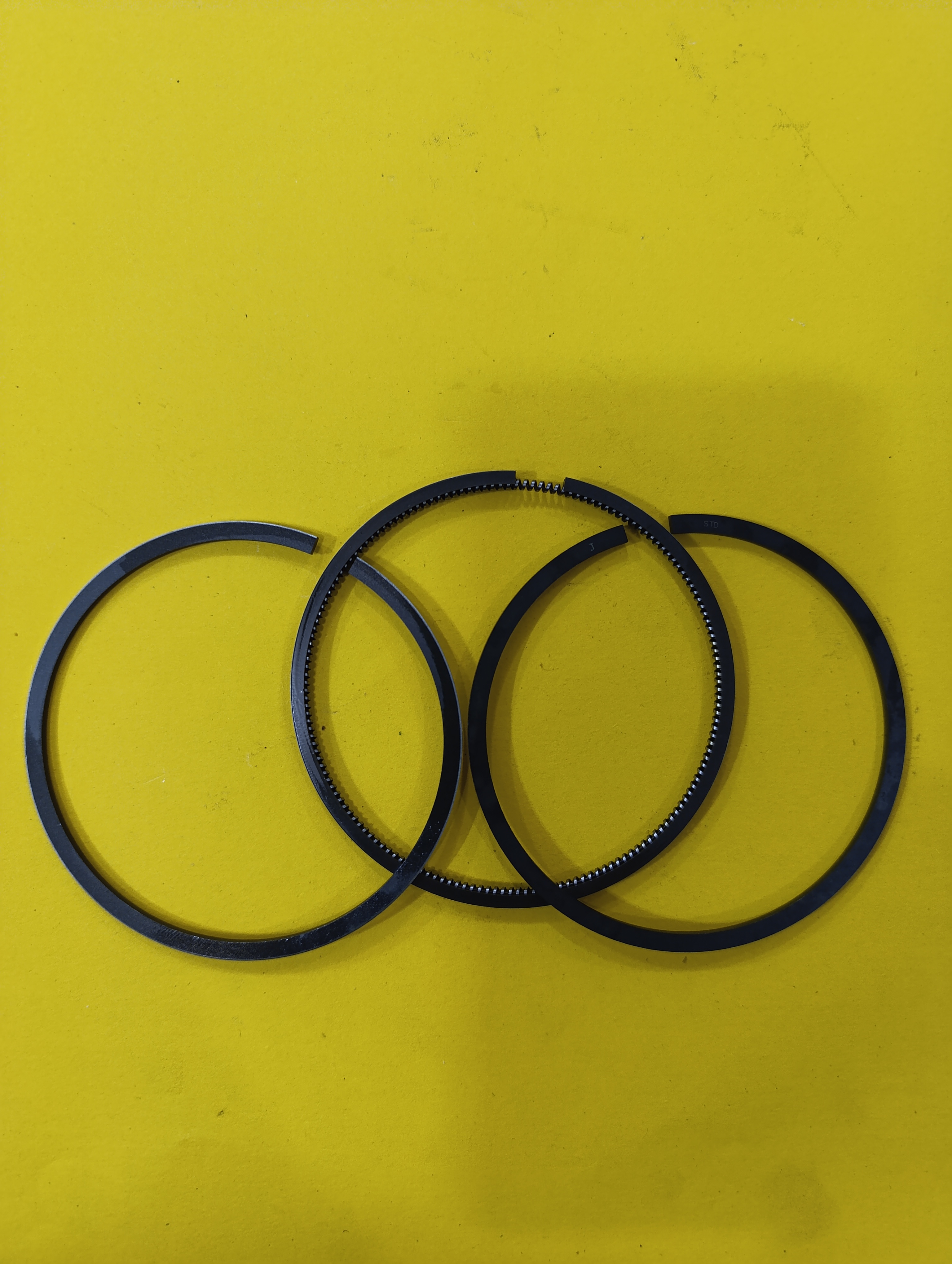  رینگ تک 186f,fa25 موتور دیزل ده اسب  - رینگ تک موتور ۱۸۶ قطعه‌ای فلزی از جنس چدن خاکستری است که روی پیستون موتور دیزل ۱۸۶ نصب می‌شود و وظیفه اصلی آن ایجاد آب‌بندی بین پیستون و جداره سیلندر است. این رینگ‌ها از نشت گازهای احتراق جلوگیری کرده و مانع نفوذ روغن به محفظه احتراق می‌شوند، همچنین اصطکاک بین قطعات متحرک موتور را کاهش می‌دهند. معمولاً سه عدد رینگ روی پیستون قرار می‌گیرد که نقش مهمی در عملکرد صحیح و دوام موتور دارند