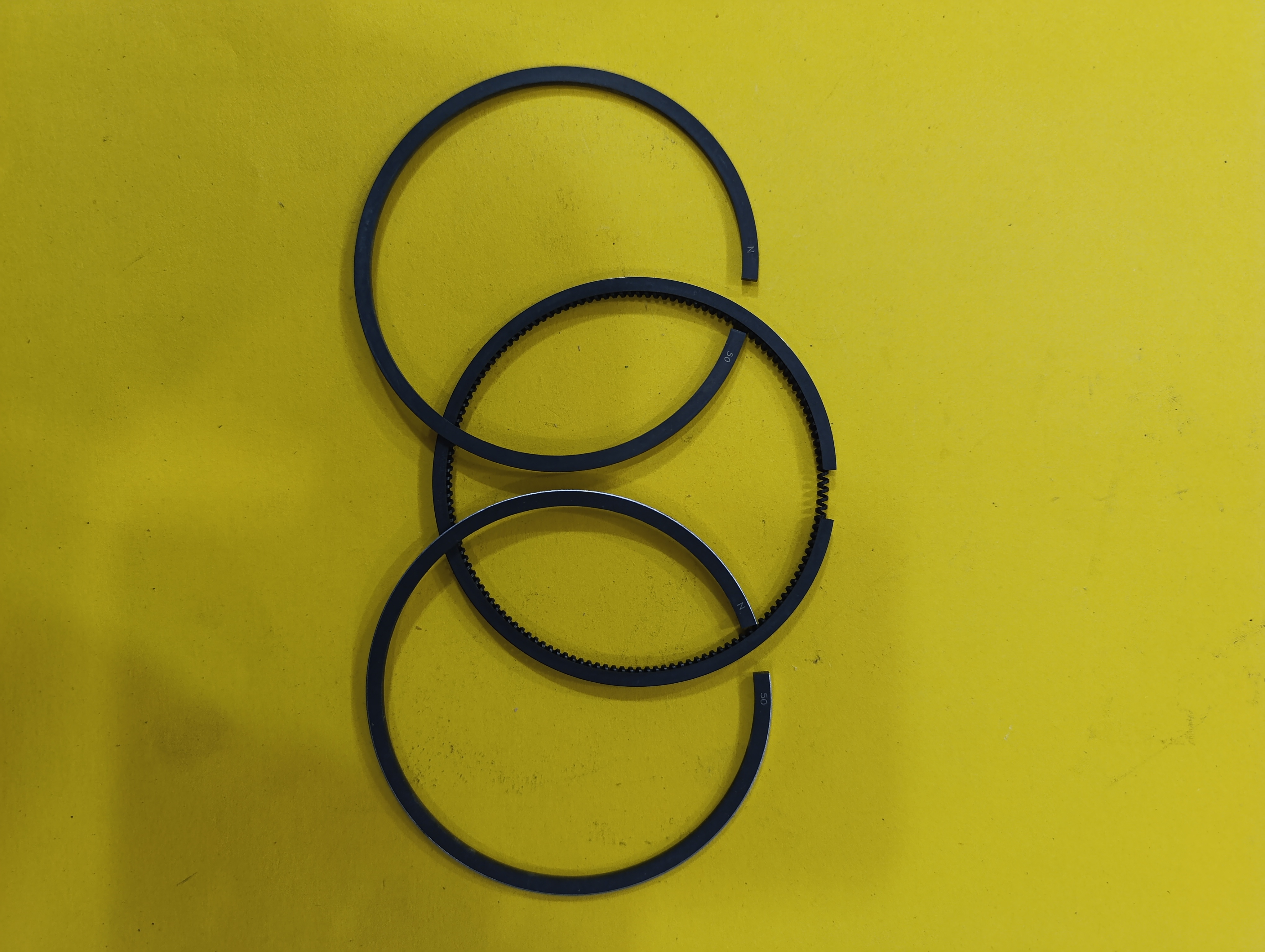  رینگ تک 186f,fa,50 موتور دیزل ده اسب - رینگ تک موتور ۱۸۶ قطعه‌ای فلزی از جنس چدن خاکستری است که روی پیستون موتور دیزل ۱۸۶ نصب می‌شود و وظیفه اصلی آن ایجاد آب‌بندی بین پیستون و جداره سیلندر است. این رینگ‌ها از نشت گازهای احتراق جلوگیری کرده و مانع نفوذ روغن به محفظه احتراق می‌شوند، همچنین اصطکاک بین قطعات متحرک موتور را کاهش می‌دهند. معمولاً سه عدد رینگ روی پیستون قرار می‌گیرد که نقش مهمی در عملکرد صحیح و دوام موتور دارند